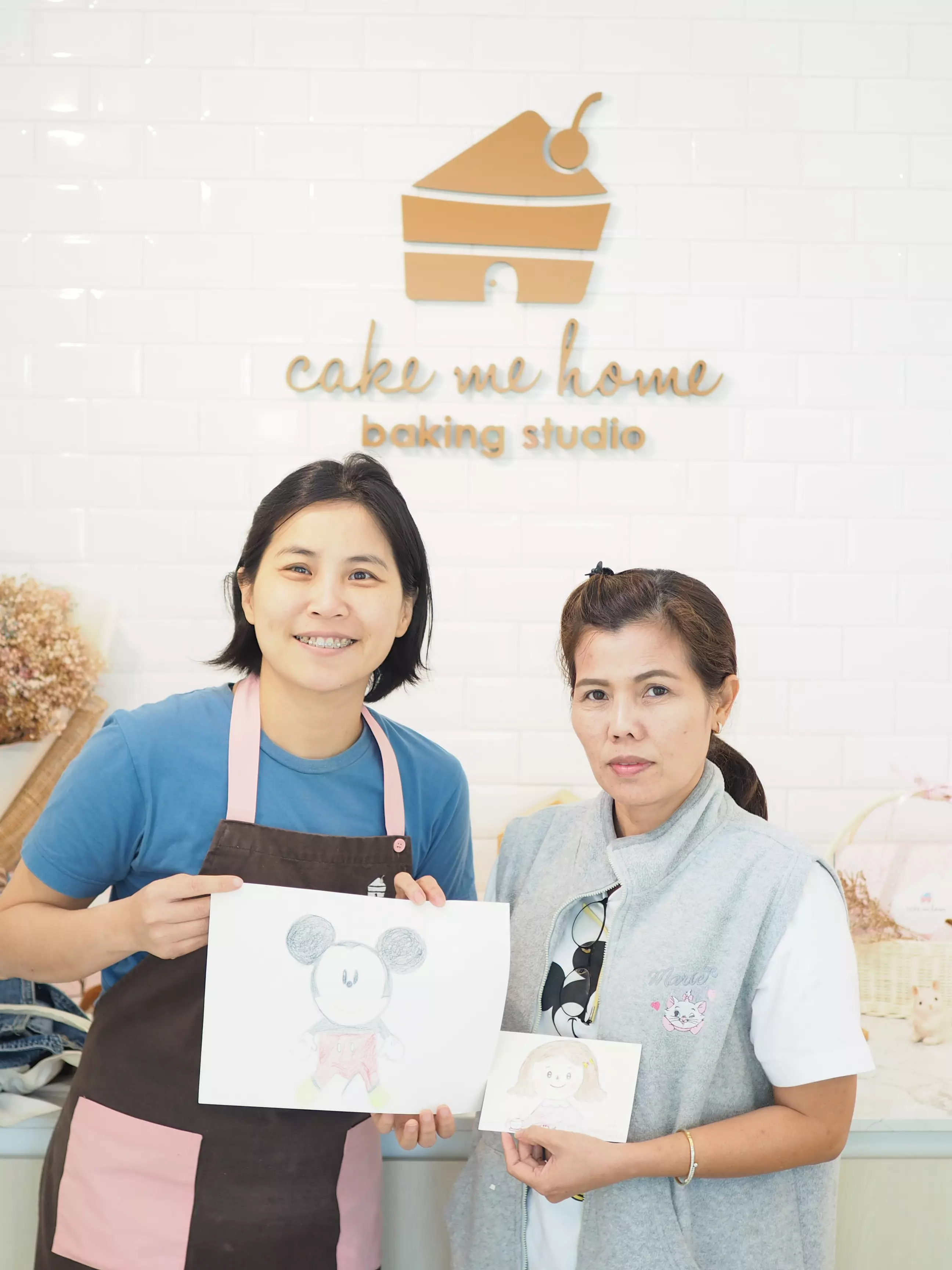 โพสท่าคู่ภาพวาดมิกกี้ใต้โลโก้สตูดิโอ