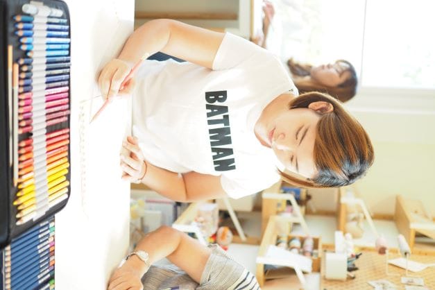 ผู้เรียนเสื้อลาย Batman กำลังวาดรูป
